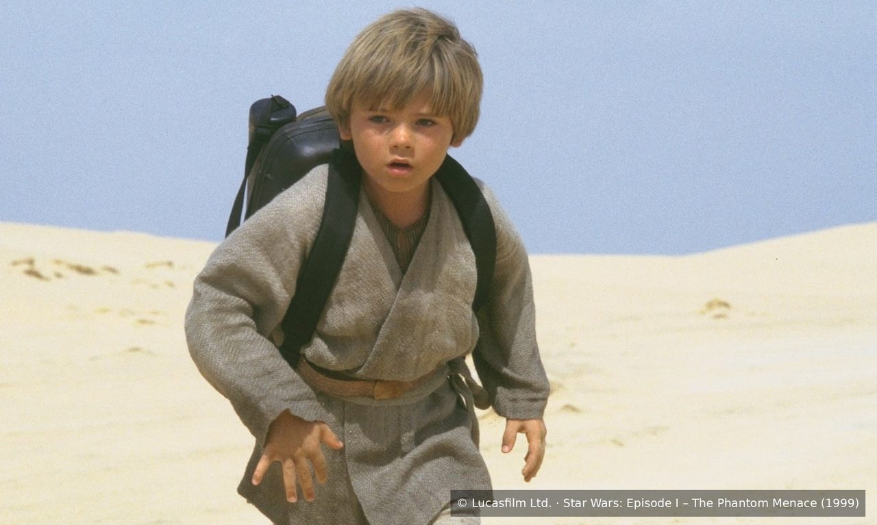 Young Anakin Skywalker hurrying across a desert dune in a still from The Phantom Menace